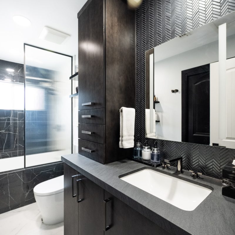 bath remodel with black vanity and white floor tiles